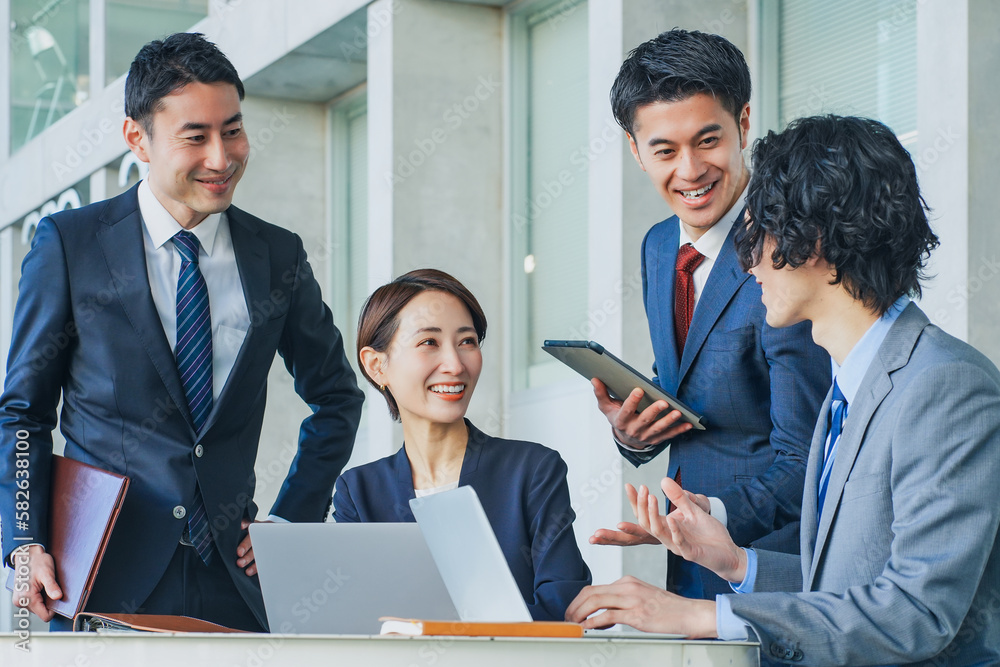 オフィスで会話する3人のビジネスパーソン